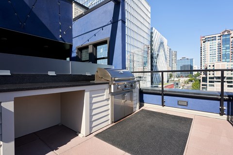 a kitchen with a grill and a city skyline in the background